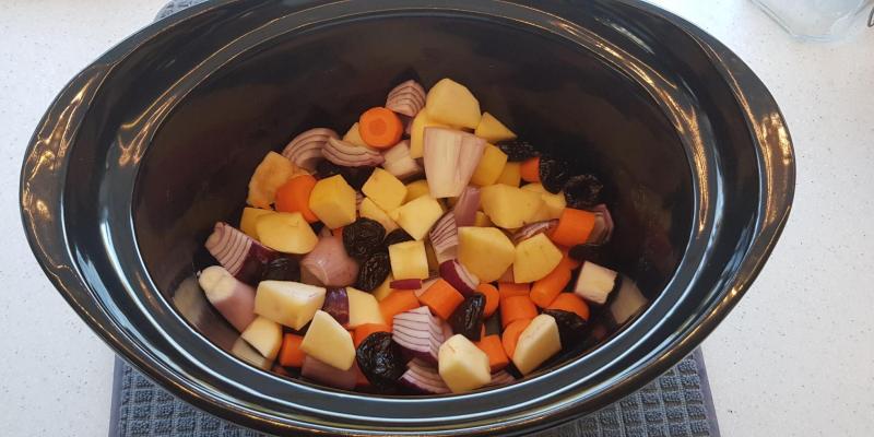 Fläskkarré på en bädd av morötter, katrinplommon, lök och äpplen